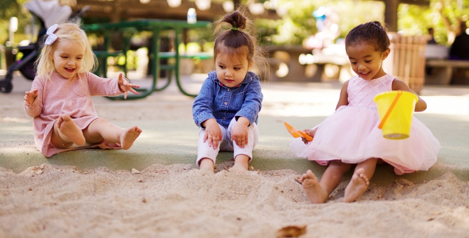 three kids playing in sandbox